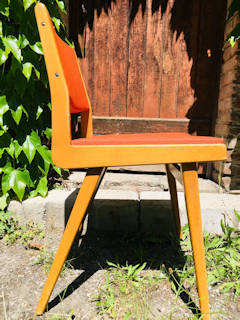 Chaise Skaï orange, structure bois, pieds compas, dans son jus.