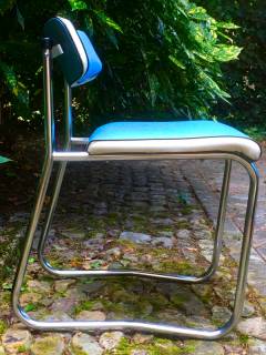 Chaise dans l’esprit Pullman, style administration, structure chromée en forme de traîneau, assise et dossier en skai bleu et blanc. Dimensions: H 65, L 45, P 45, H assise 45.