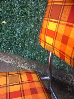 Duo de chaises, chaises de cuisine des années 60/70, entièrement d’origine, structure en métal chromé, assise et dossier confortables, recouverts de skai, motifs à carreaux, couleur dominante orange, la mousse ayant gardé sa densité.
