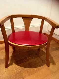 Siège Baumann en bois, assise recouverte de Skaï rouge, hauteur assise 24cm, hauteur dossier 38cm.