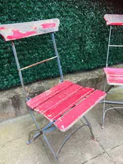 Paire de chaises anciennes de jardin, pliantes, structure métal, assise et dossier en lattes de bois, peinture rouge d’origine écaillée, dans leur jus.