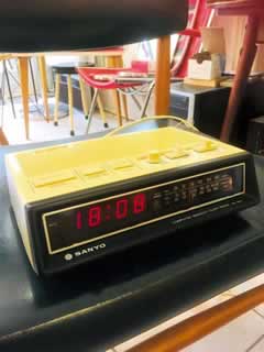 Radio réveil Sanyo vintage, des années 70, boîtier en plastique beige, écran noir avec affichage digital rouge, radio FM, MW, LW. Dimensions H 7.5, L 25, P 17.5