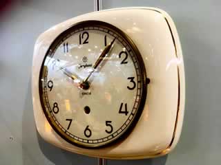 Horloge murale en faïence, en état de fonctionnement, système remontoir remplacé par mécanisme quartz, à pile standard.