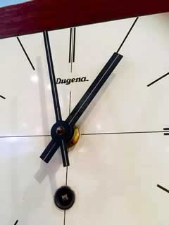 Horloge murale Dugena, en bois, à remontoir, clé présente.