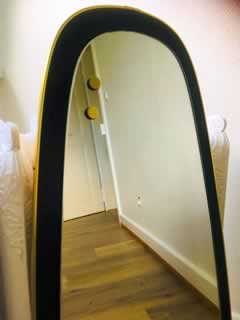 Miroir rétro asymétrique, bordure plastique doré, H 83cm, l max 38,5cm.