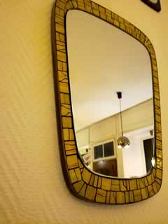 Miroir à bordure en céramique, forme libre, dim: H 45 cm; l 31 cm.