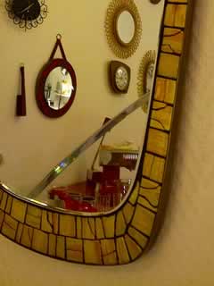 Miroir à bordure en céramique, forme libre, dim: H 45 cm; l 31 cm.