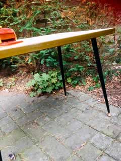 Table basse, plateau Formica beige, piètement métal fuselé, embouts de pieds rotules laiton, H 53cm, L 72cm, l 46cm.