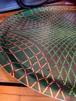 Plateau vintage en fibre de verre, motifs géométriques sur fond vert bouteille, typique des années 60/70, diamètre 37 cm.