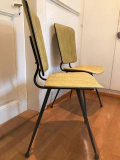 Paire de chaises jaunes, dans leur jus, structure métal noir, pieds fuseaux, revêtement Skaï jaune moucheté noir.