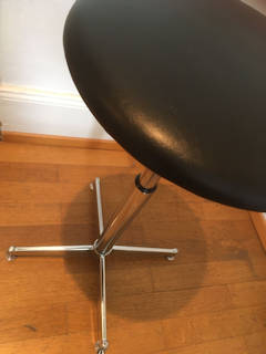 Tabouret réglable KOR 70’, assise en Skaï noir d’origine, diamètre 33 cm, piétement en acier chromé, système de réglage fonctionnel, H mini 43, H maxi 70.
