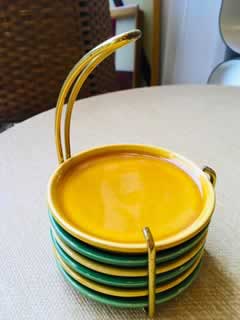 Ensemble vintage de 6 dessous de verre en faïence avec son support métal jaune, 3 de couleur jaune et 3 de couleur verte. Très bon état.